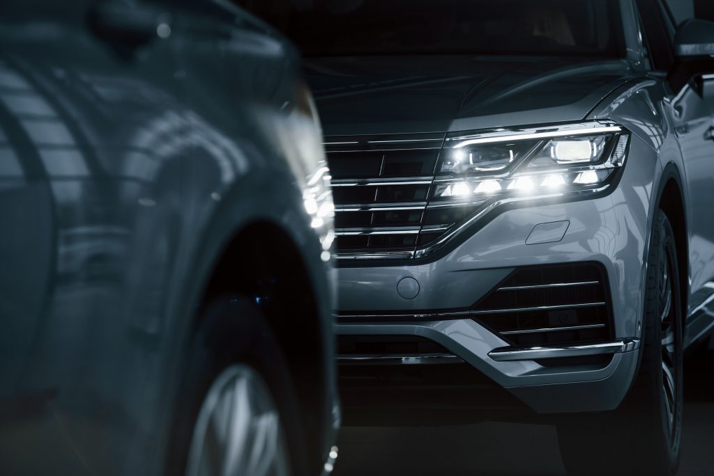 powerful-headlights-particle-view-modern-luxury-cars-parked-indoors-daytime